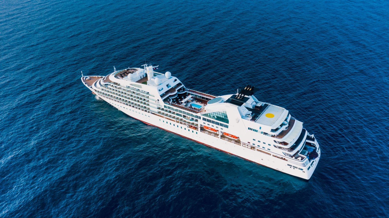 Cruise ship on a bright blue sea, seen from the air