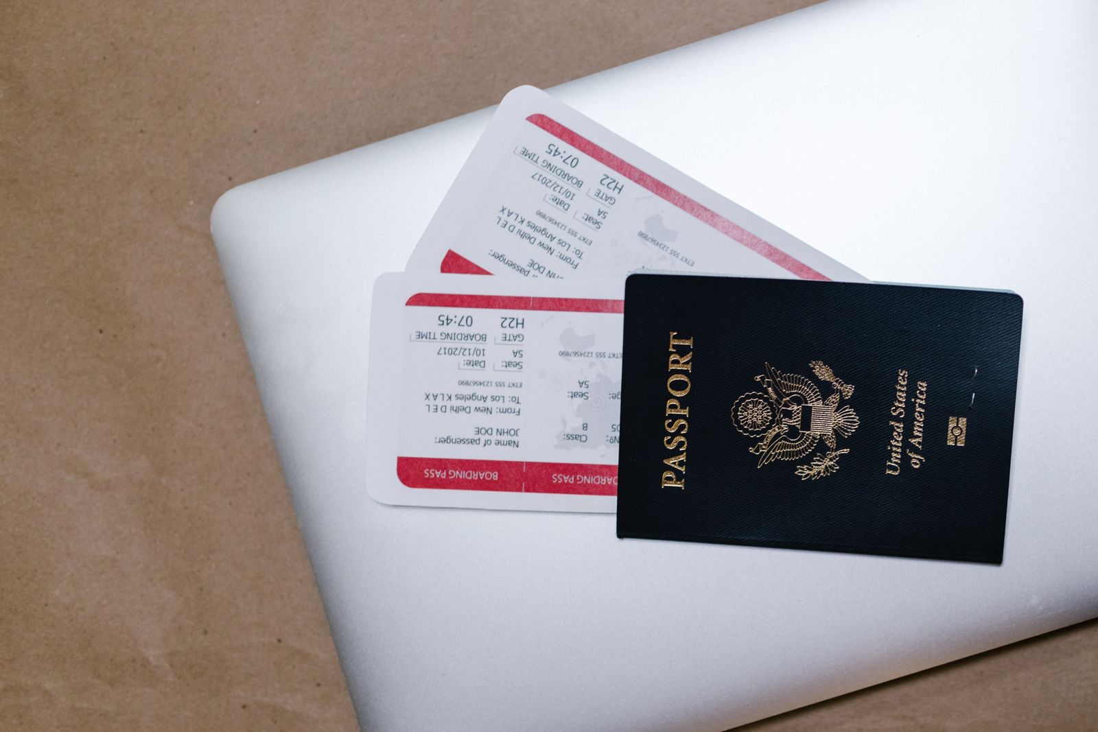 Passport and printed tickets lying on a laptop keyboard